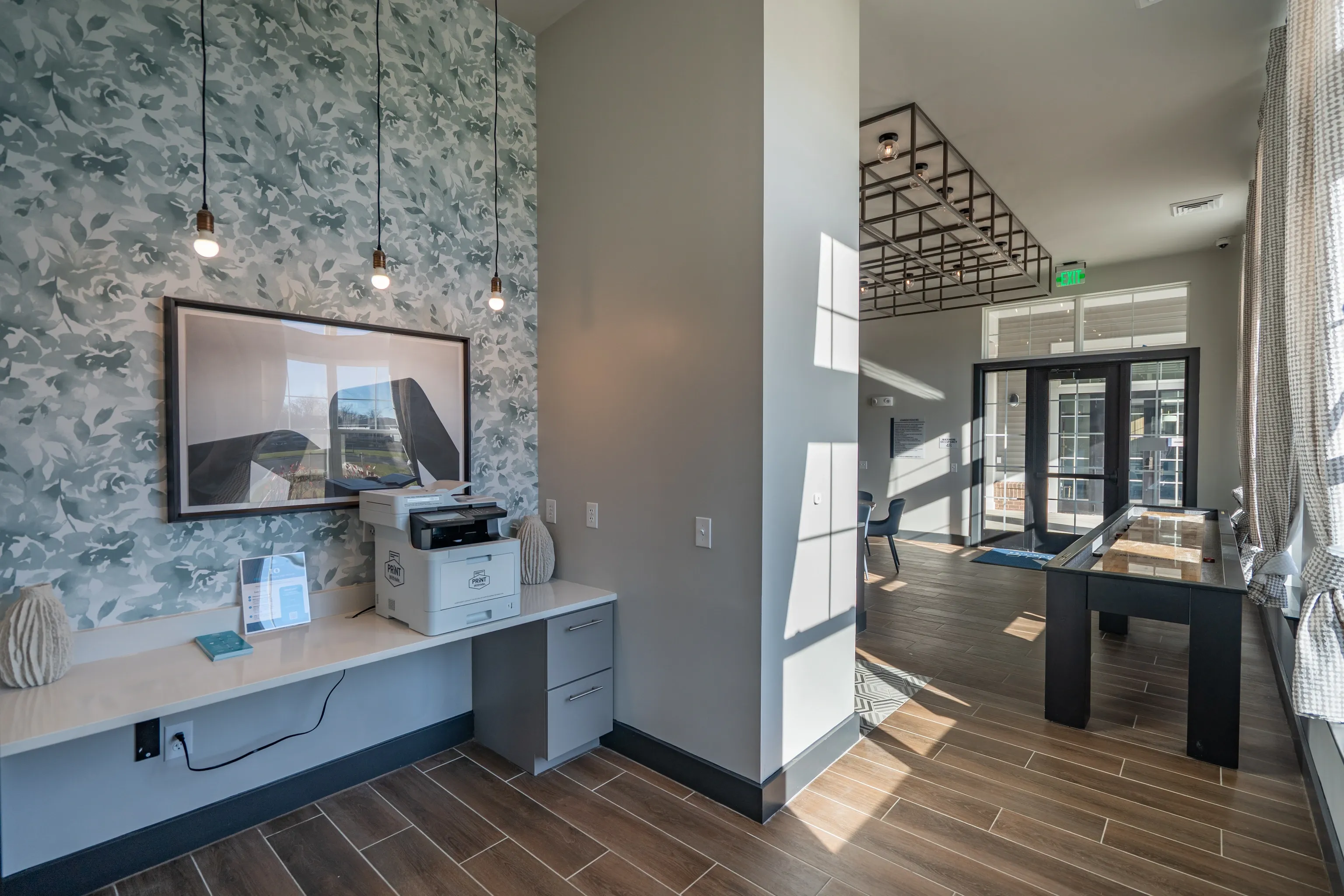 Business center with printer and shuffleboard table in the lounge area.