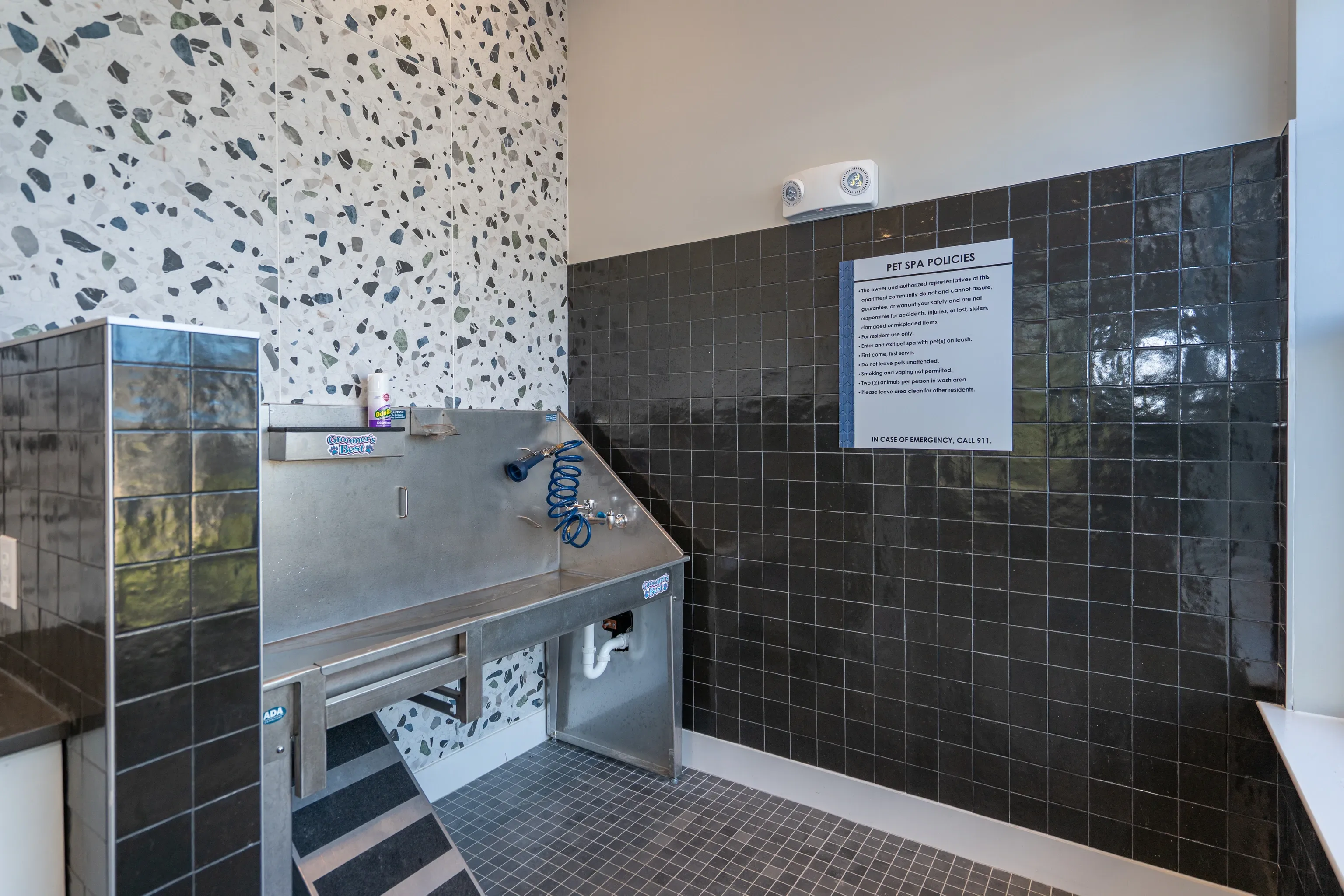 Pet spa with grooming station and policies sign.