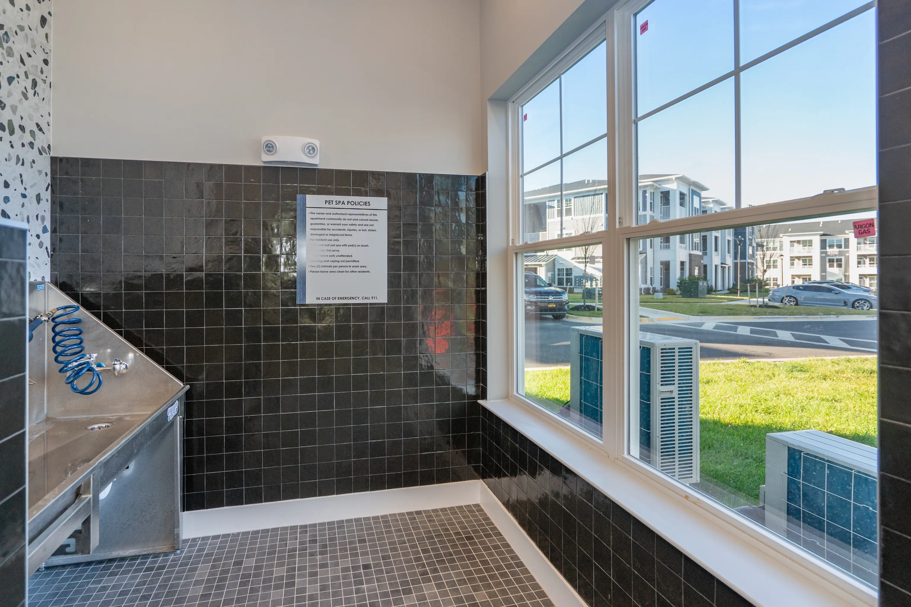 Pet spa washing station with policies sign inside an apartment building.