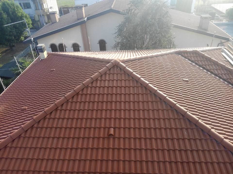 Tetti di case con tegole rosse visti dall'alto in un soleggiato quartiere residenziale