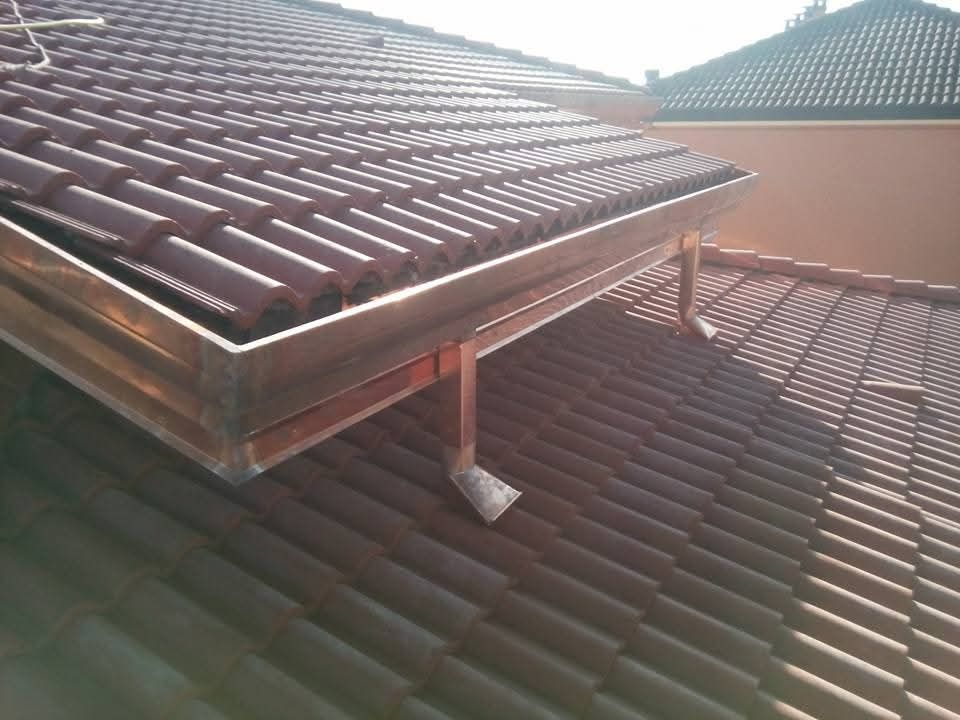 Tetto soleggiato con tende da sole in tegole rosse e il tetto di una casa vicina