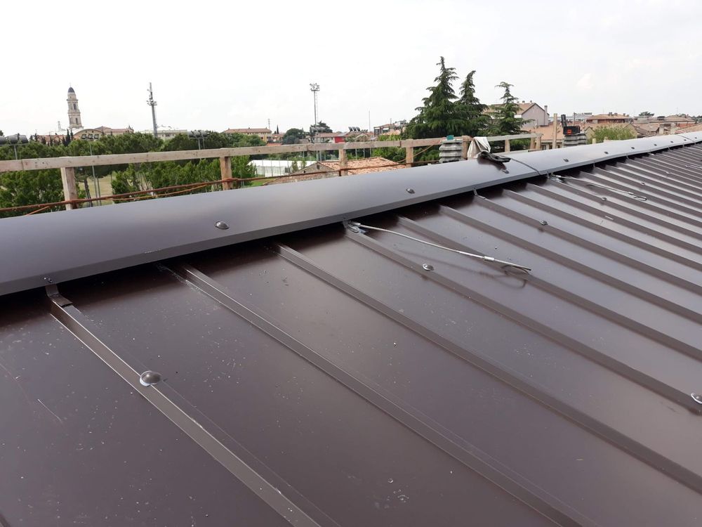 Operai edili con elmetti di sicurezza esaminano i progetti in un cantiere.