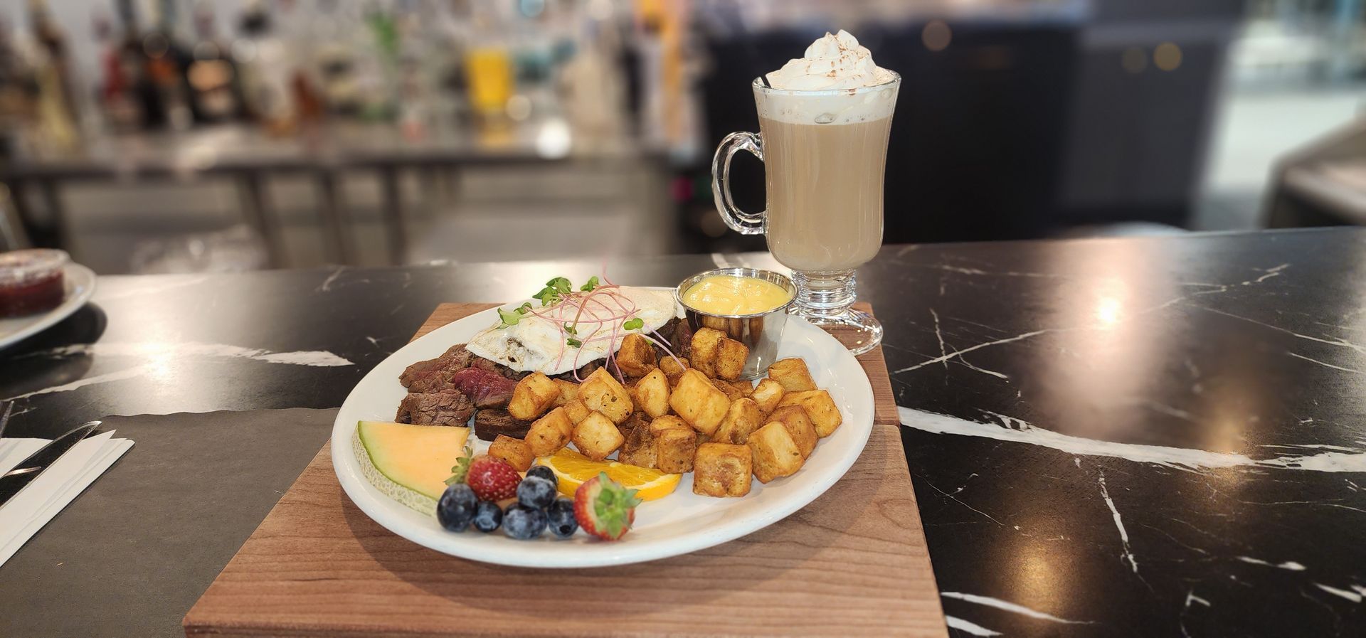 Une assiette de nourriture et une boisson sur une table.