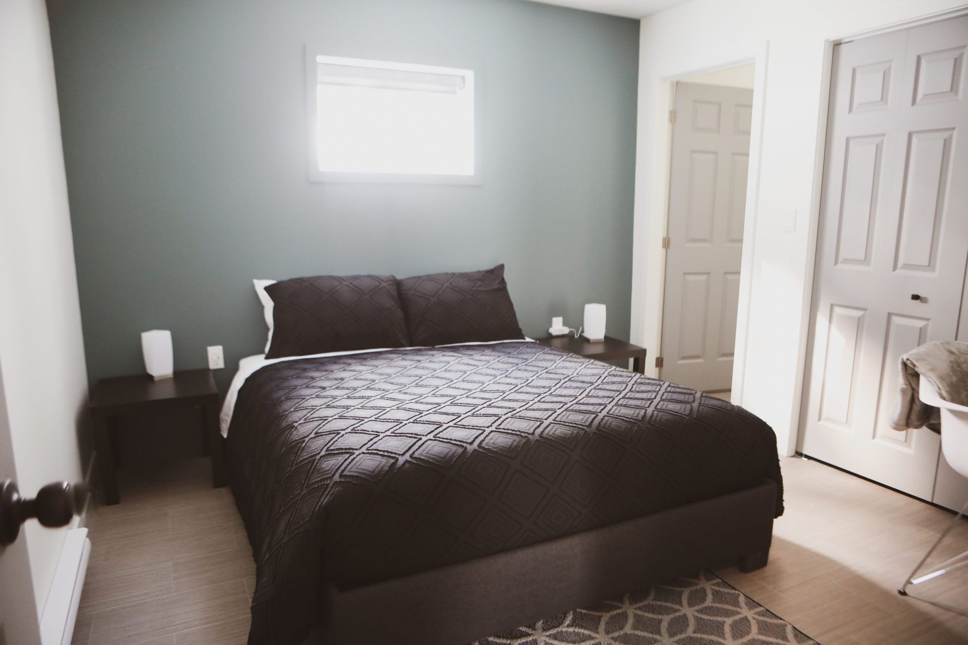 Une chambre avec un lit, des tables de nuit et une fenêtre.