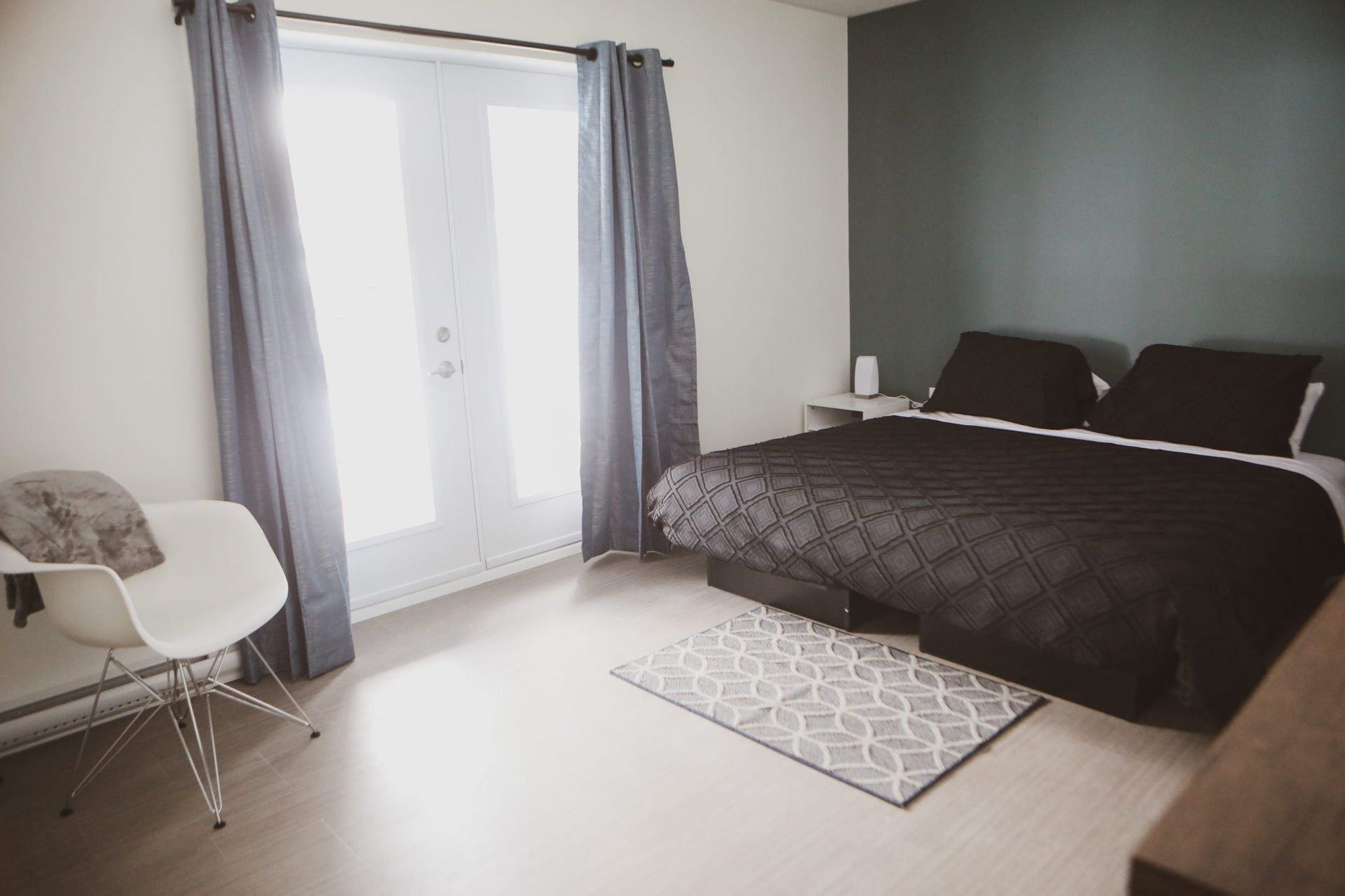 Une chambre avec un grand lit et une chaise
