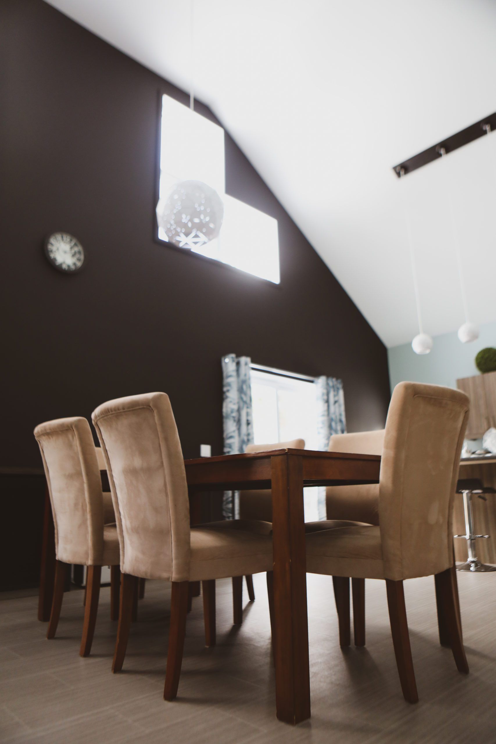 Une salle à manger avec une table et des chaises et une horloge au mur