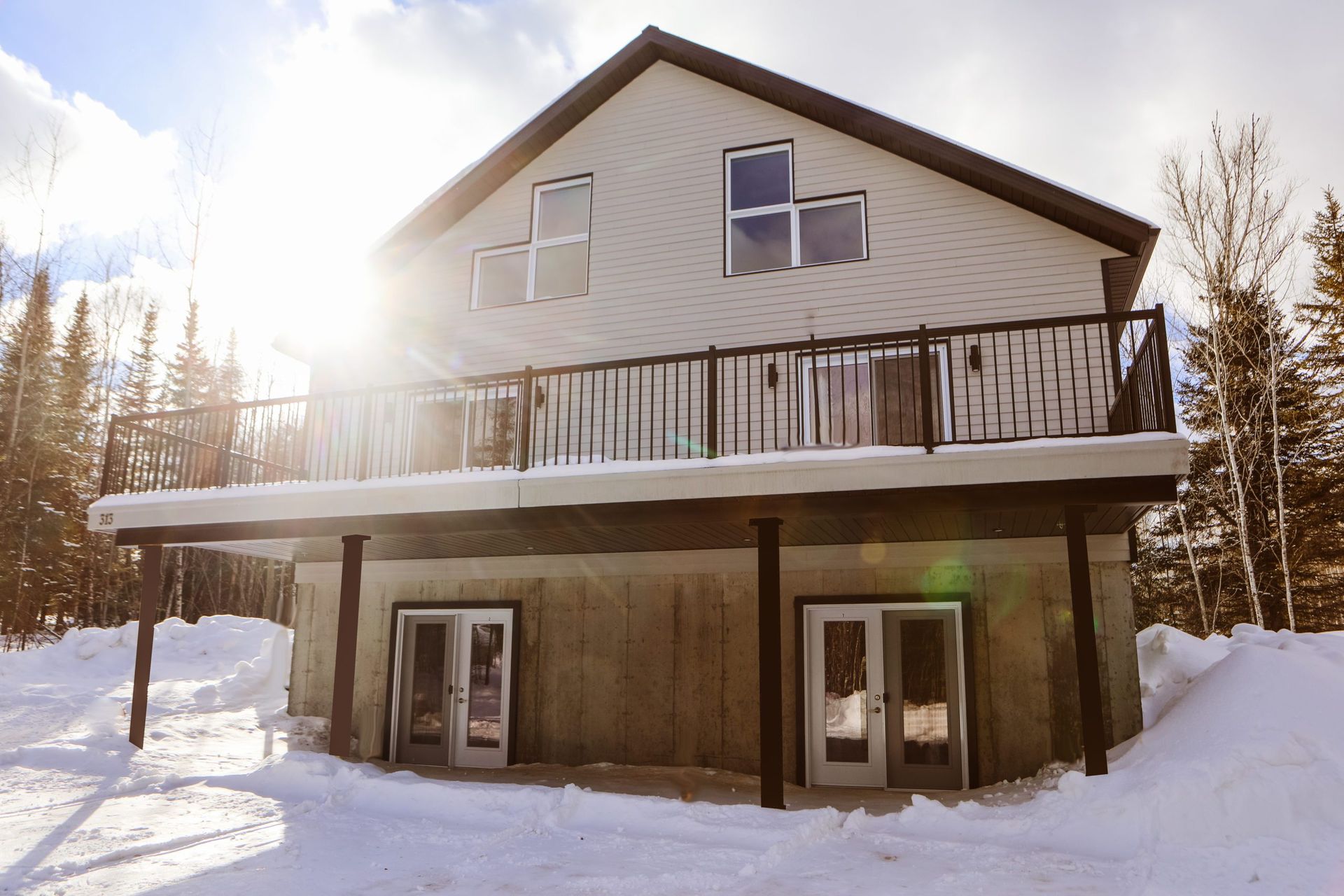 Une grande maison avec un balcon est recouverte de neige.