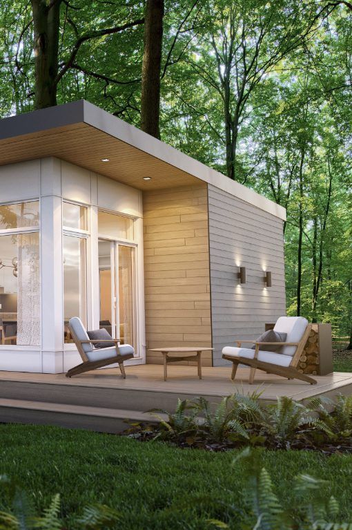 Une petite maison au milieu d'une forêt avec des chaises et une table.