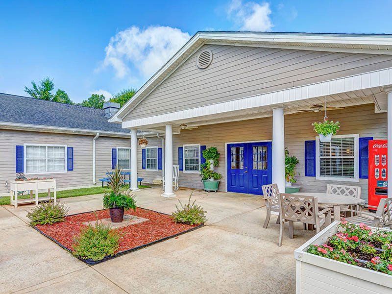 A large house with a patio and a table and chairs in front of it.