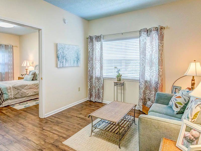 A living room with a couch , coffee table , and a bed.