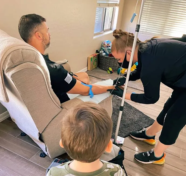 A man in a chair is getting an iv in his arm