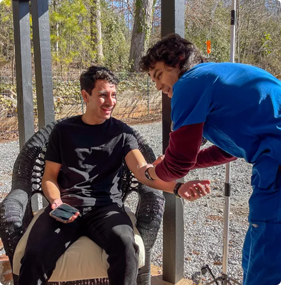 A man is sitting in a chair talking to another man