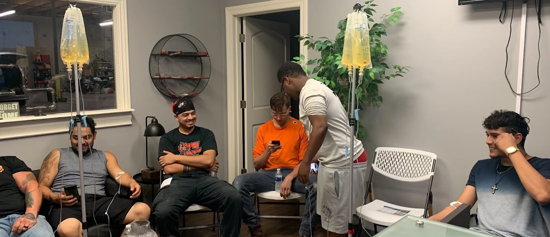 Group of men receiving IV drip therapy indoors