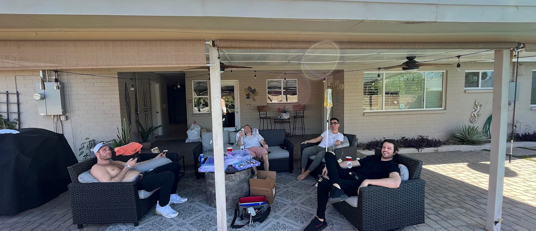 Group of friends receiving IV drip hydration therapy on patio
