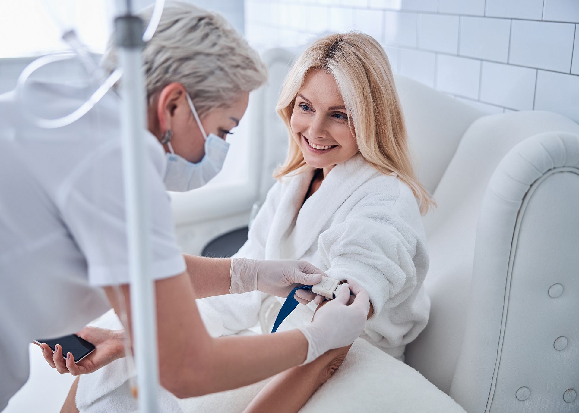 Woman receiving IV drip therapy from medical nurse