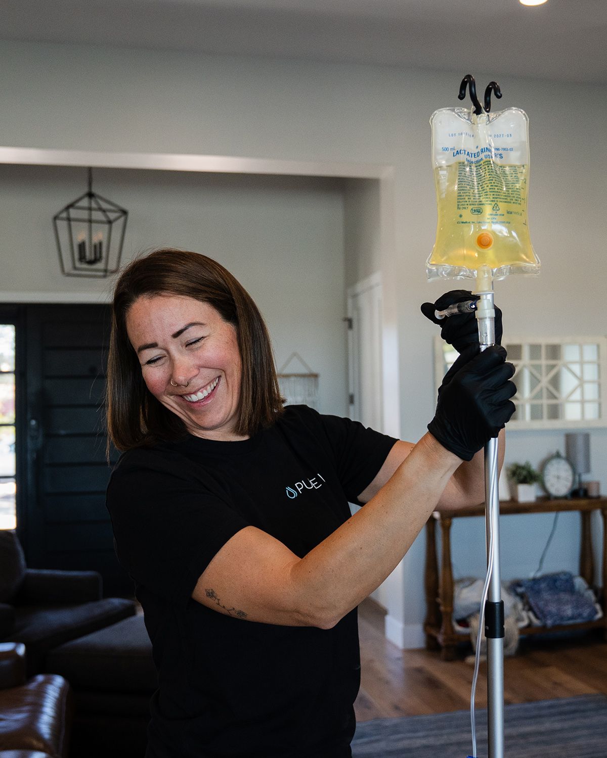 Smiling nurse setting up IV drip therapy bag