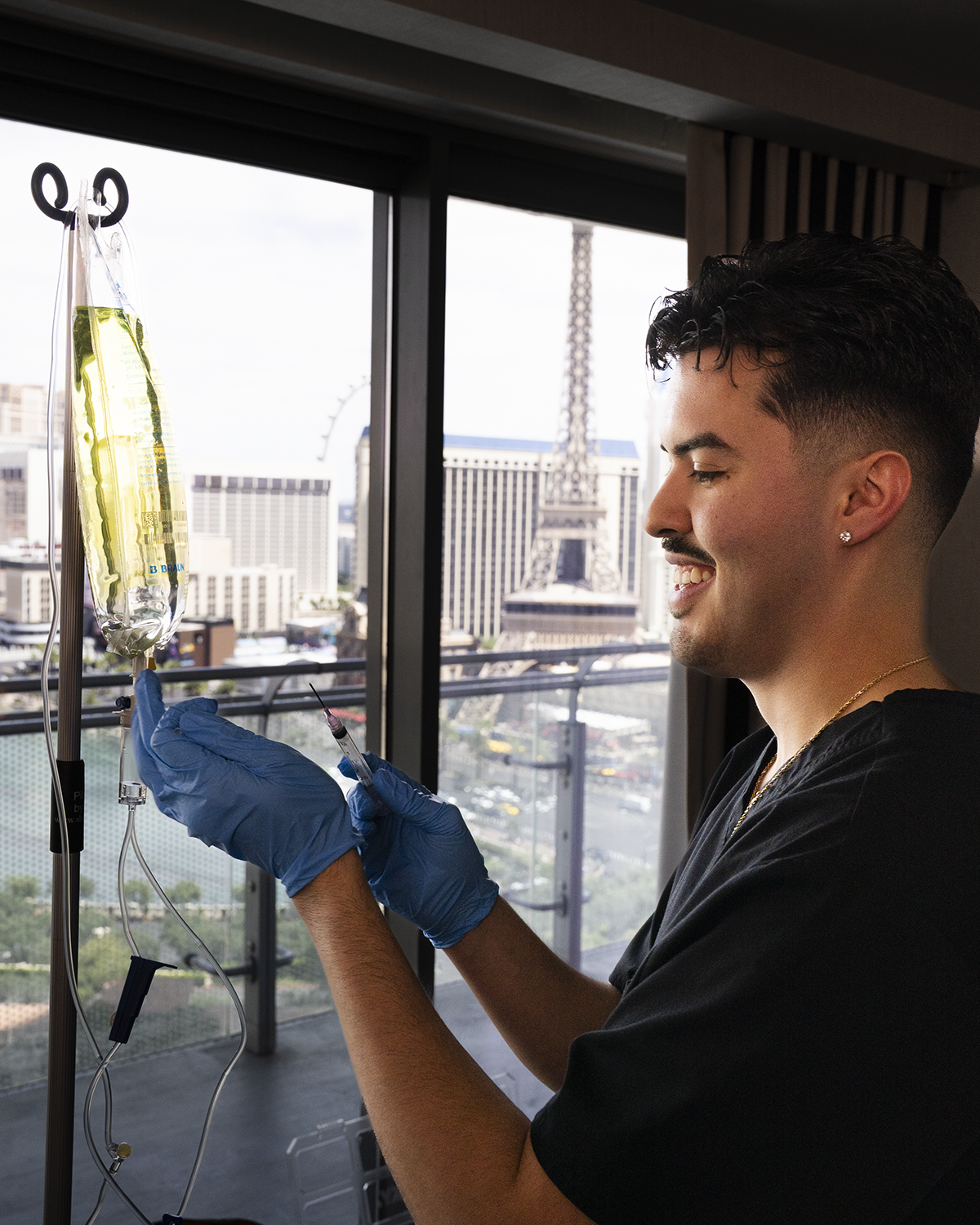 Healthcare provider preparing IV drip bag near window