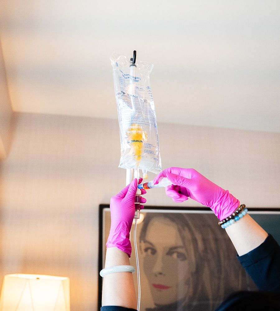 Nurse in pink gloves preparing IV drip bag