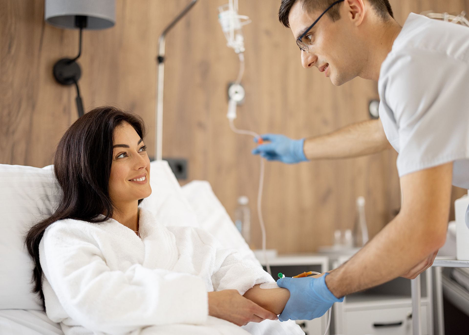 Nurse administering mobile IV therapy to patient in bed