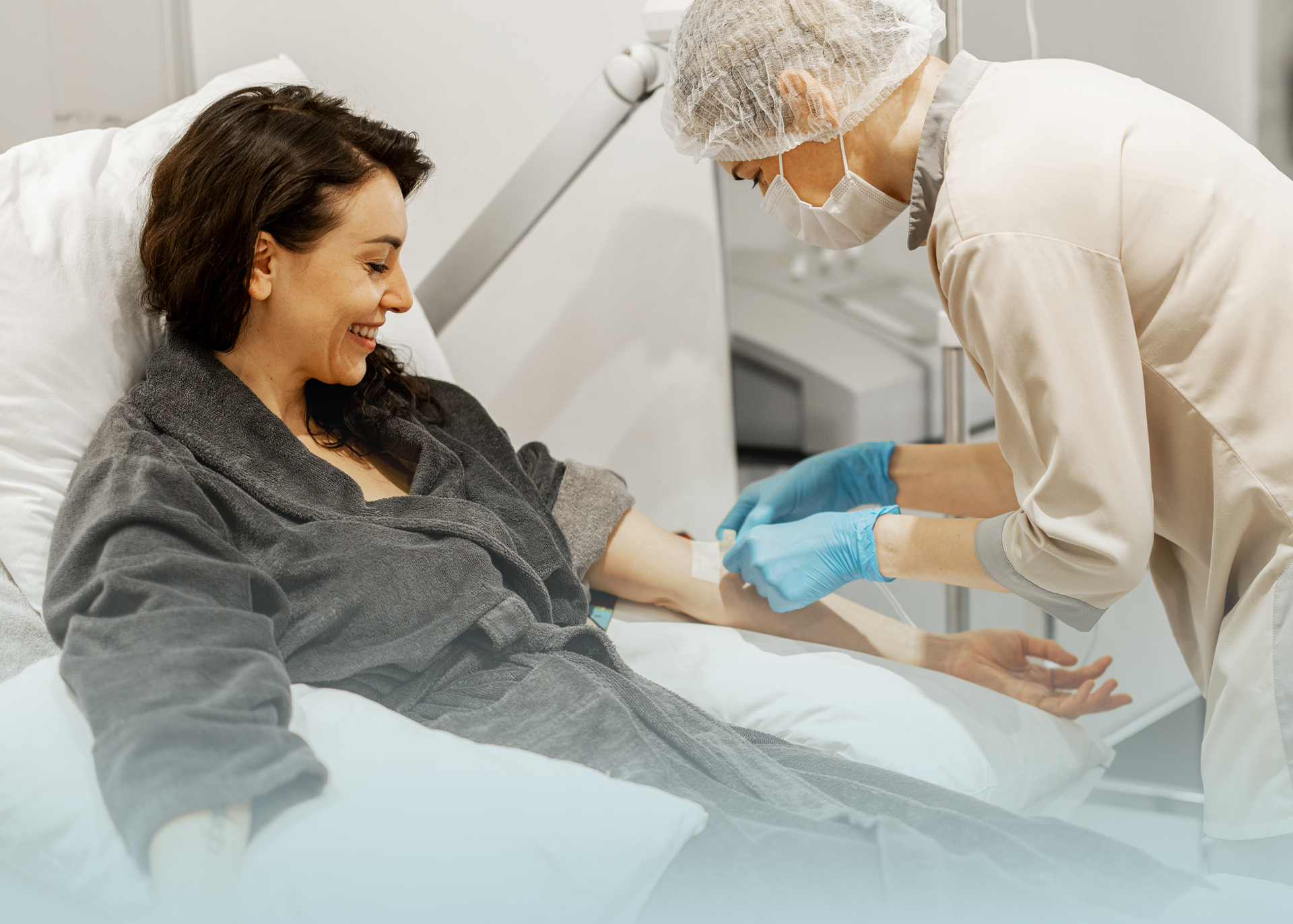 Woman smiling while receiving medical IV procedure from nurse