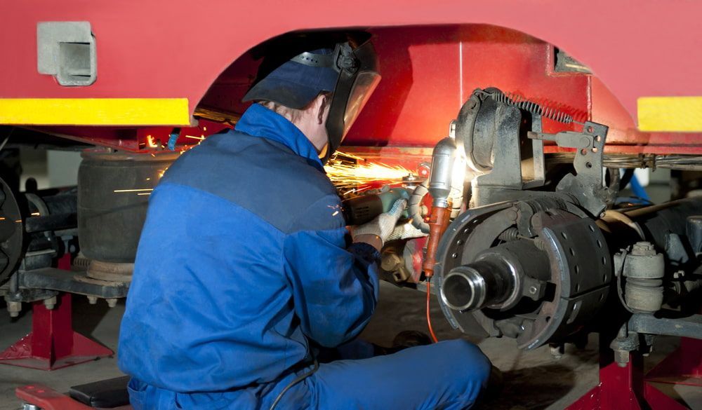 A Man Wearing a Welding Mask is Working on a Vehicle — North Coast Steel Fabrication in South Lismore, NSW