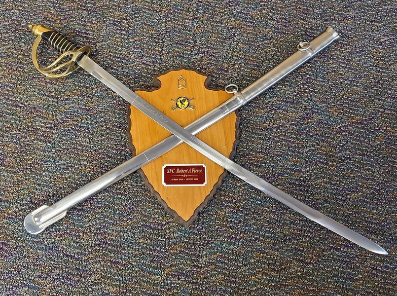 Two crossed swords are hanging on a wooden plaque.