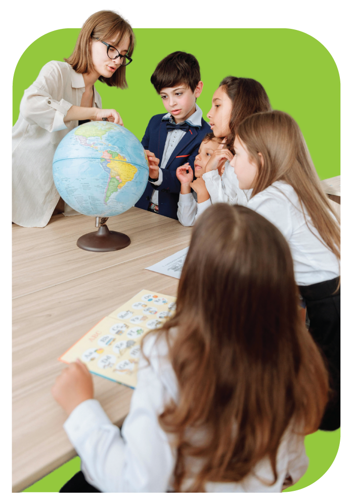 A group of students standing around a globe while a teacher explains