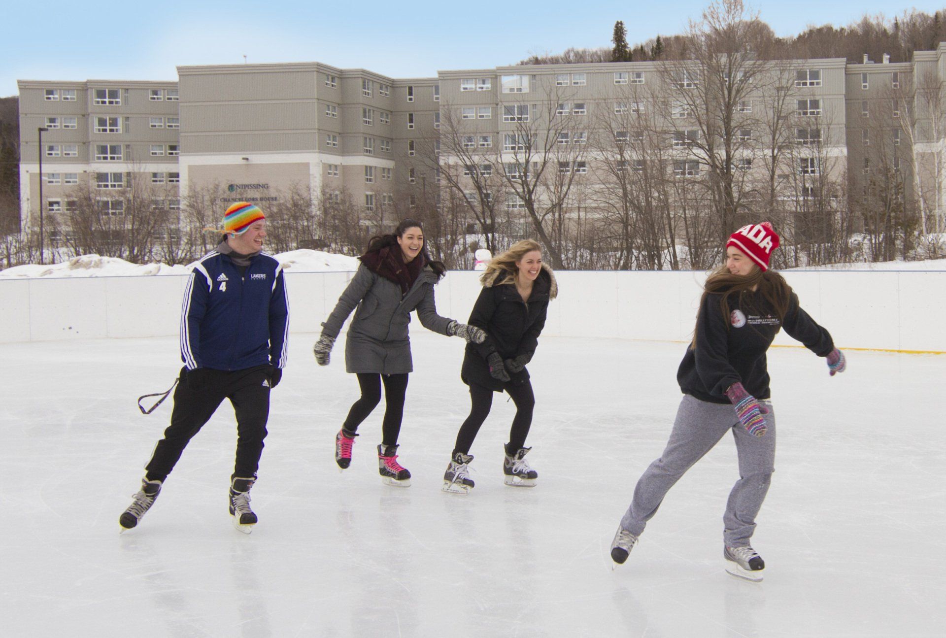 A group of people are ice skating on a rink
