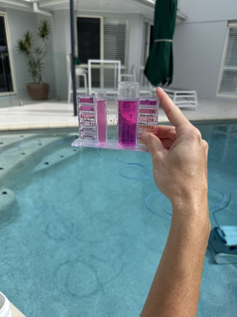 A Person Is Holding a Test Tube in Front of A Swimming Pool — Poolside Noosa in Noosaville, QLD