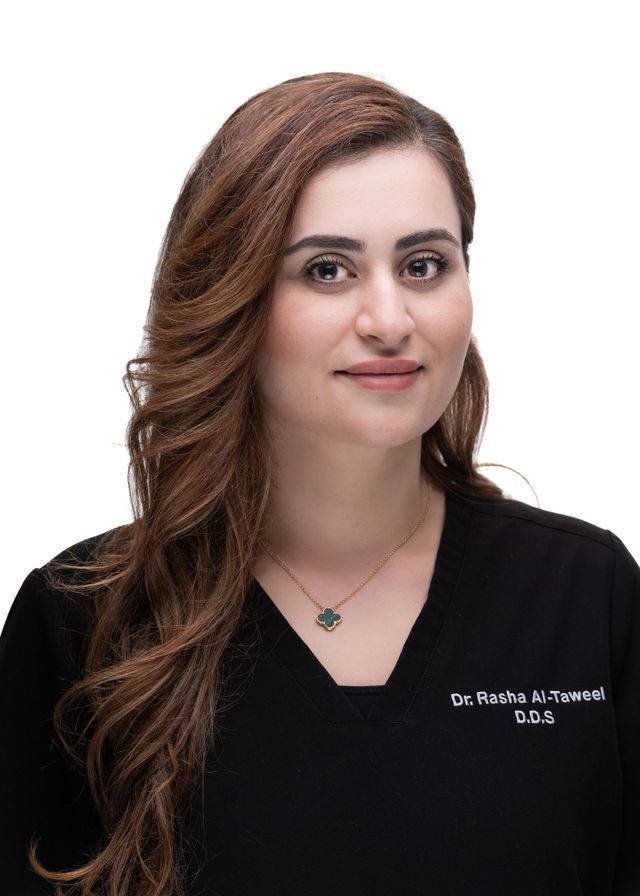 Woman with brown hair in black scrubs; wearing a necklace.