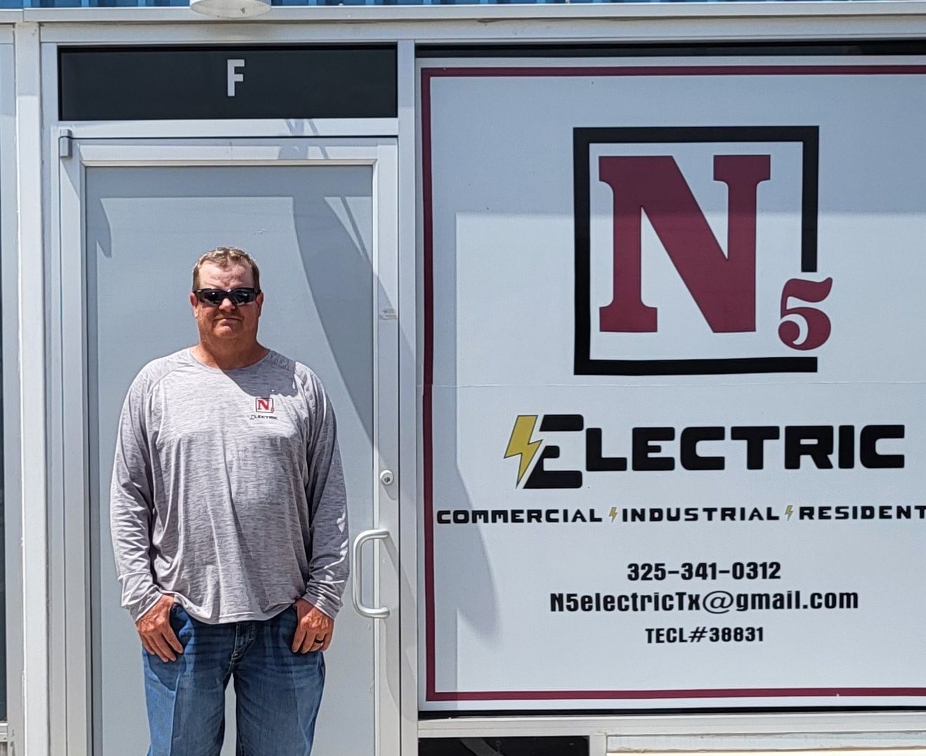 A man standing in front of a sign that says n5 electric
