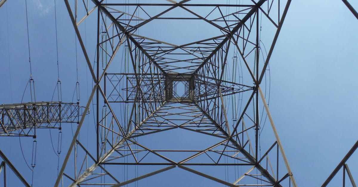 Looking up at a power tower with a blue sky in the background.