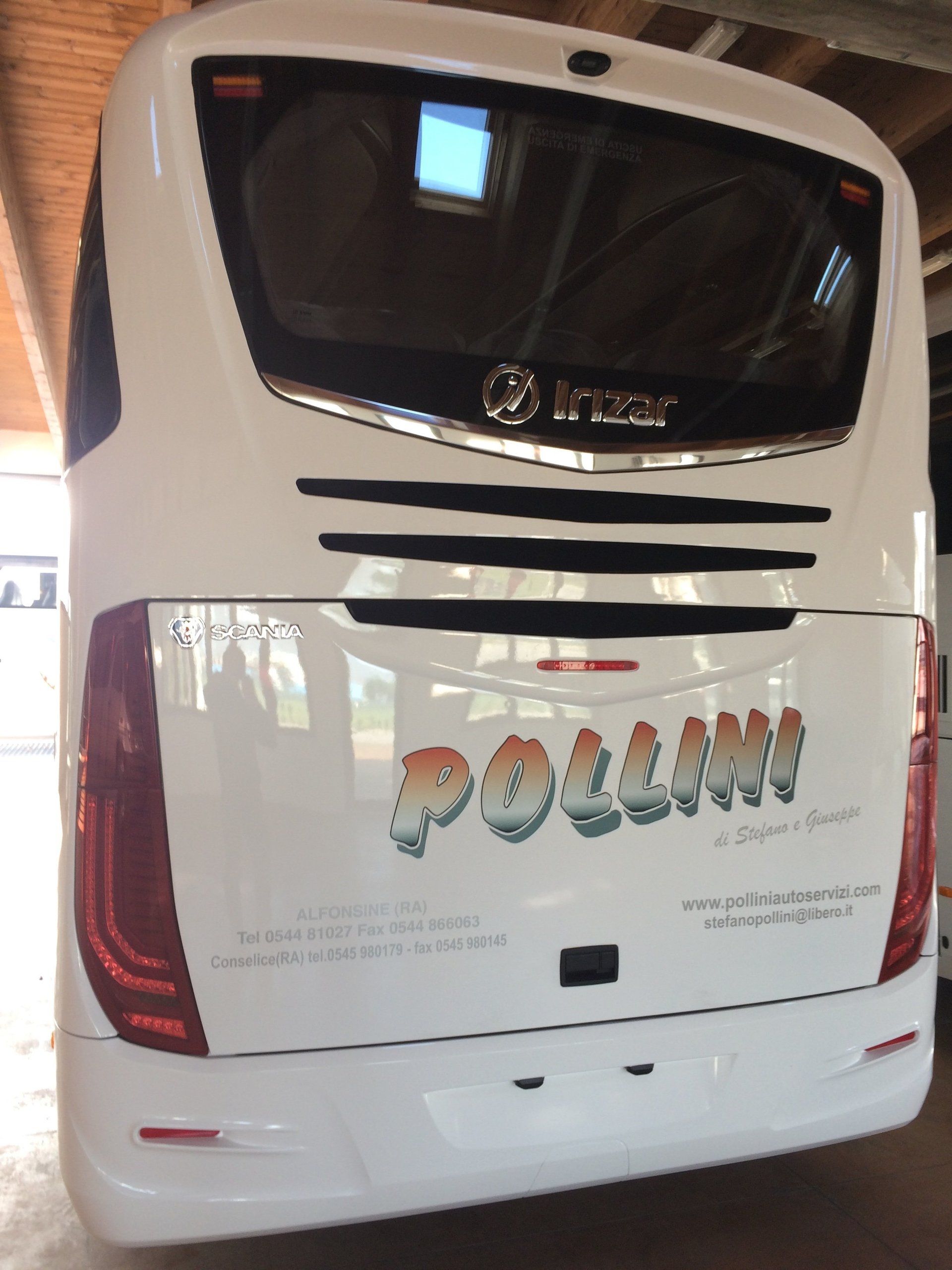Rear of a white Pollini bus with rear lights and logo.