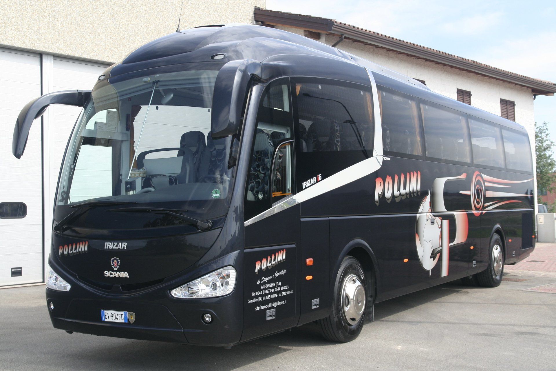Black bus parked in front of a building; it bears the word