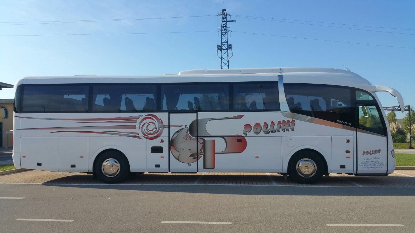 A white tourist bus parked on a road. The word