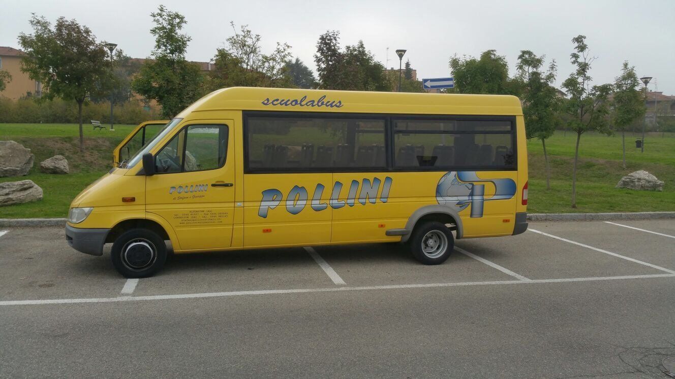 A yellow school bus parked in a car park, with the door open. The words 'School Bus' and 'POLLINO' are written on the side.