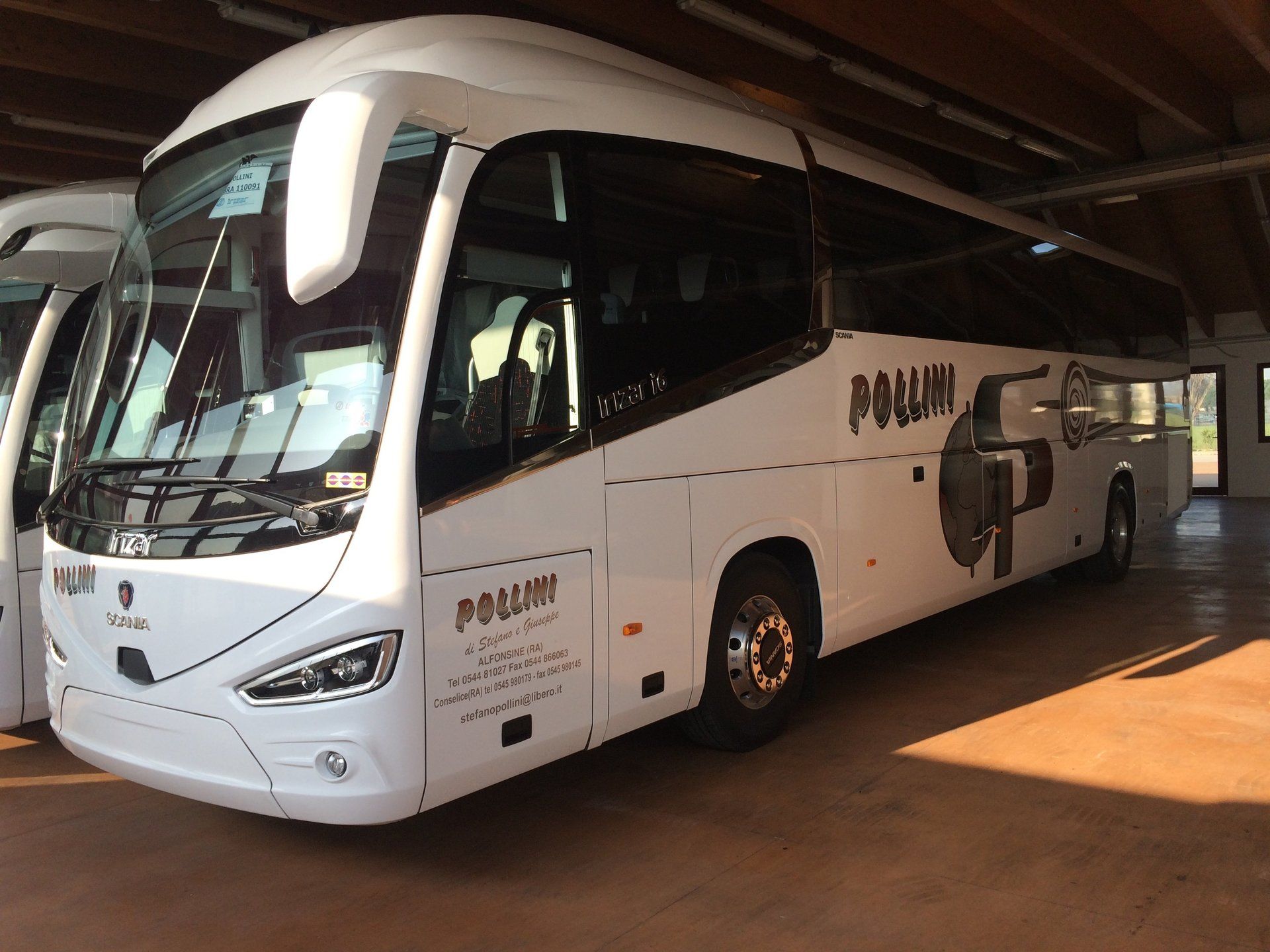 White coach parked in a garage;