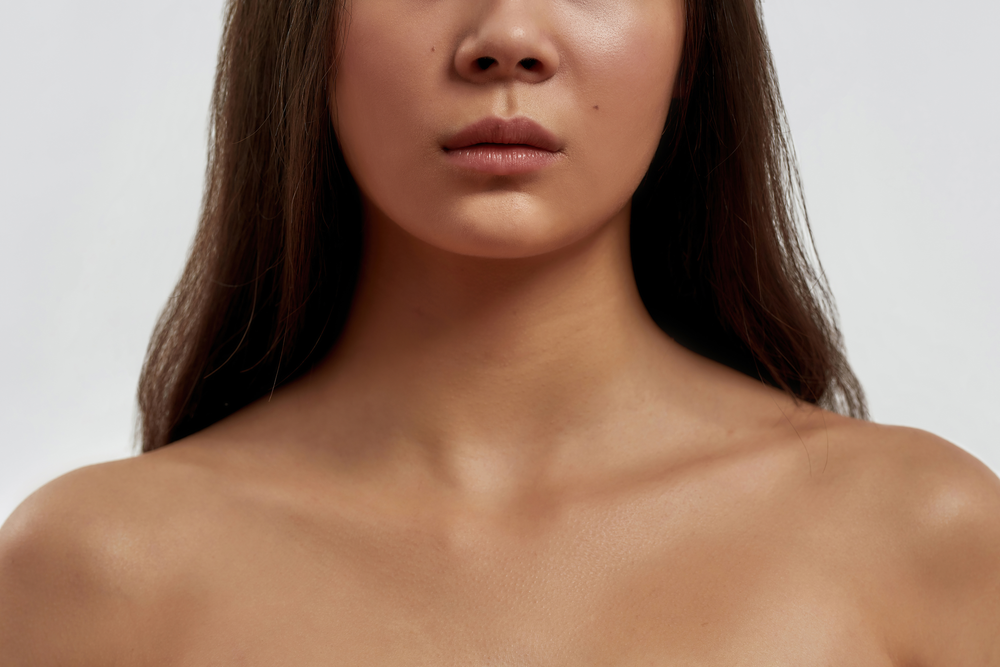 A close up of a woman 's neck and chest without a shirt on.