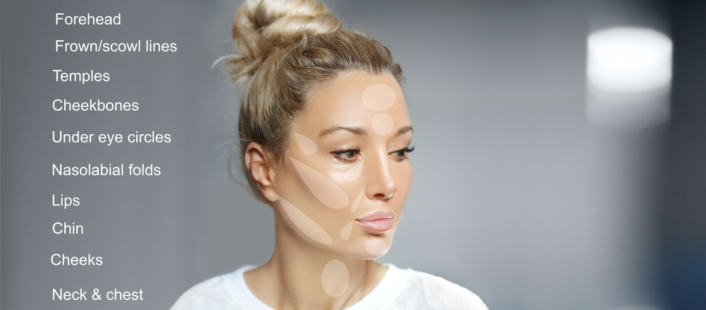 A woman with a bun on her head is looking at her face.