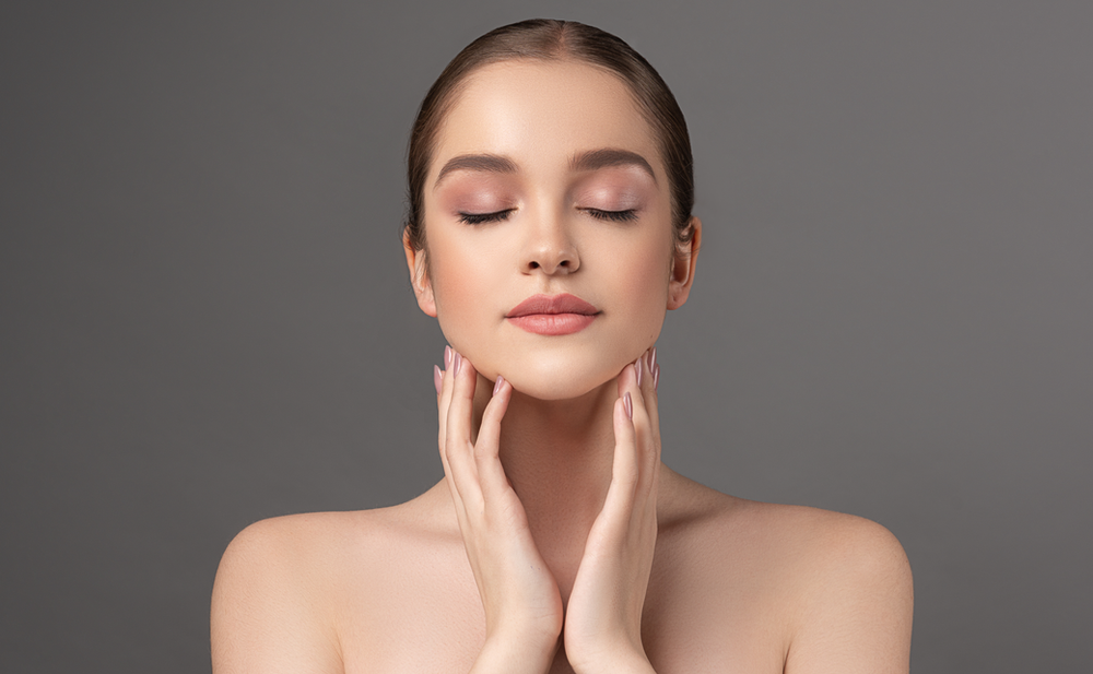 woman with glowing skin is modeling her face