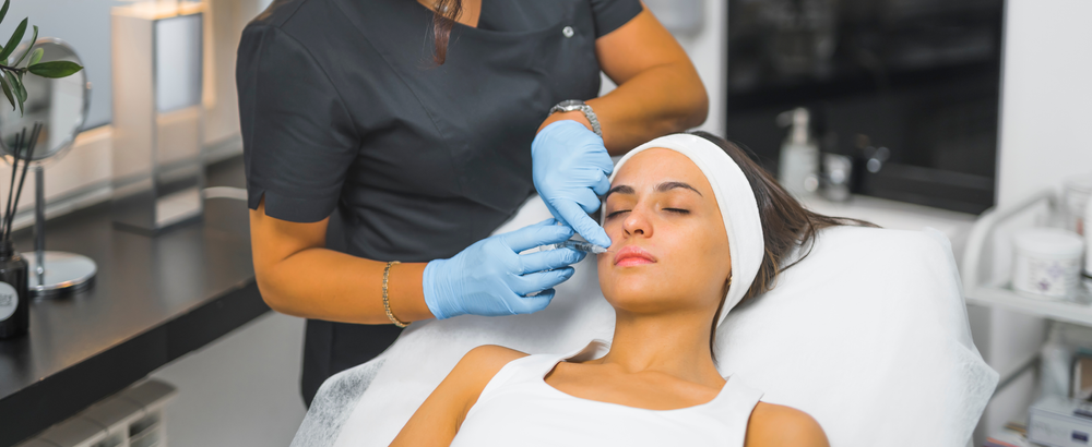 A woman is getting a facial treatment at a beauty salon.
