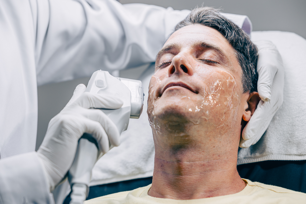 A man is getting a treatment on his face.