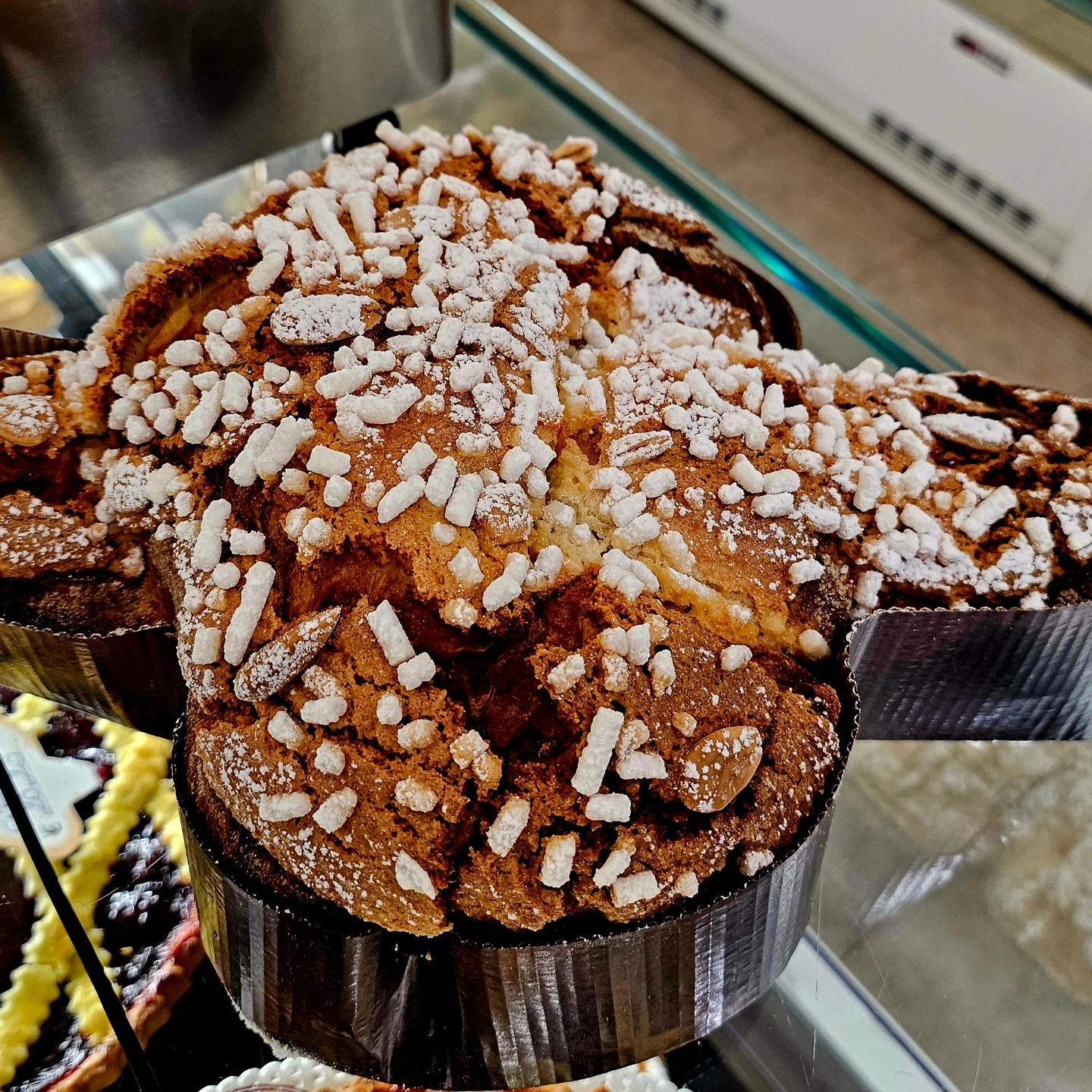 Primo piano di un pasticcino al cioccolato ricoperto di zucchero a velo e codette bianche su un vassoio