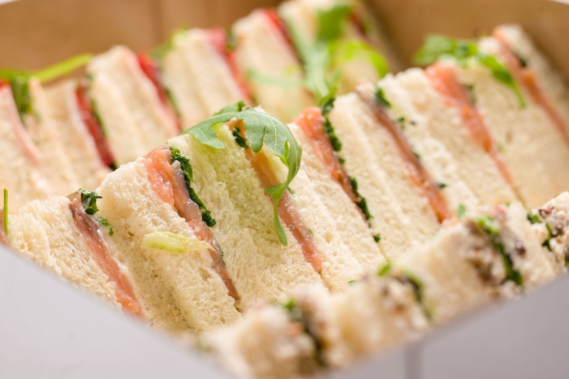 Panini assortiti con verdure, impilati in file su un vassoio.