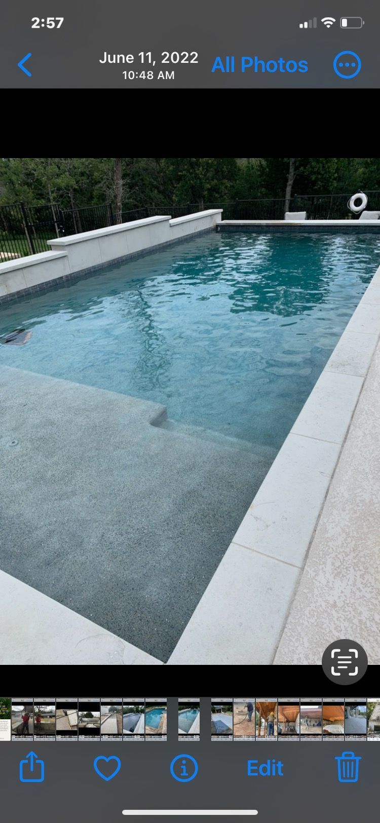 A phone screen shows a picture of a swimming pool.