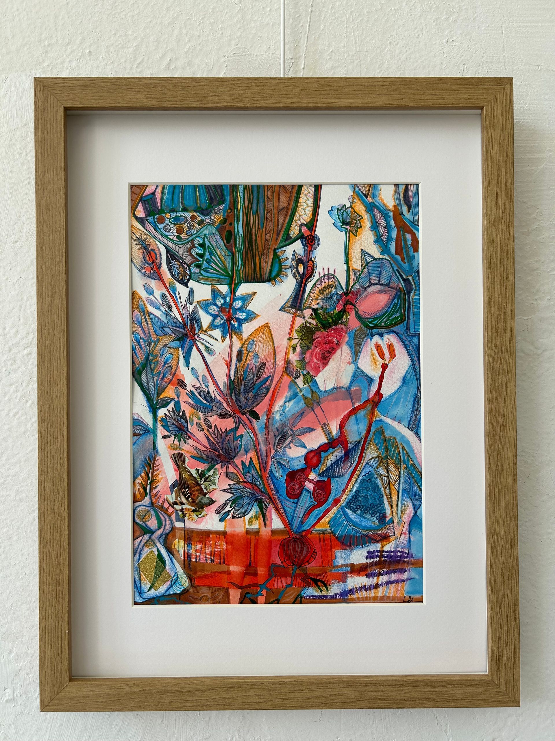 Abstract, kleurrijk bloemenschilderij in een houten lijst aan de muur.