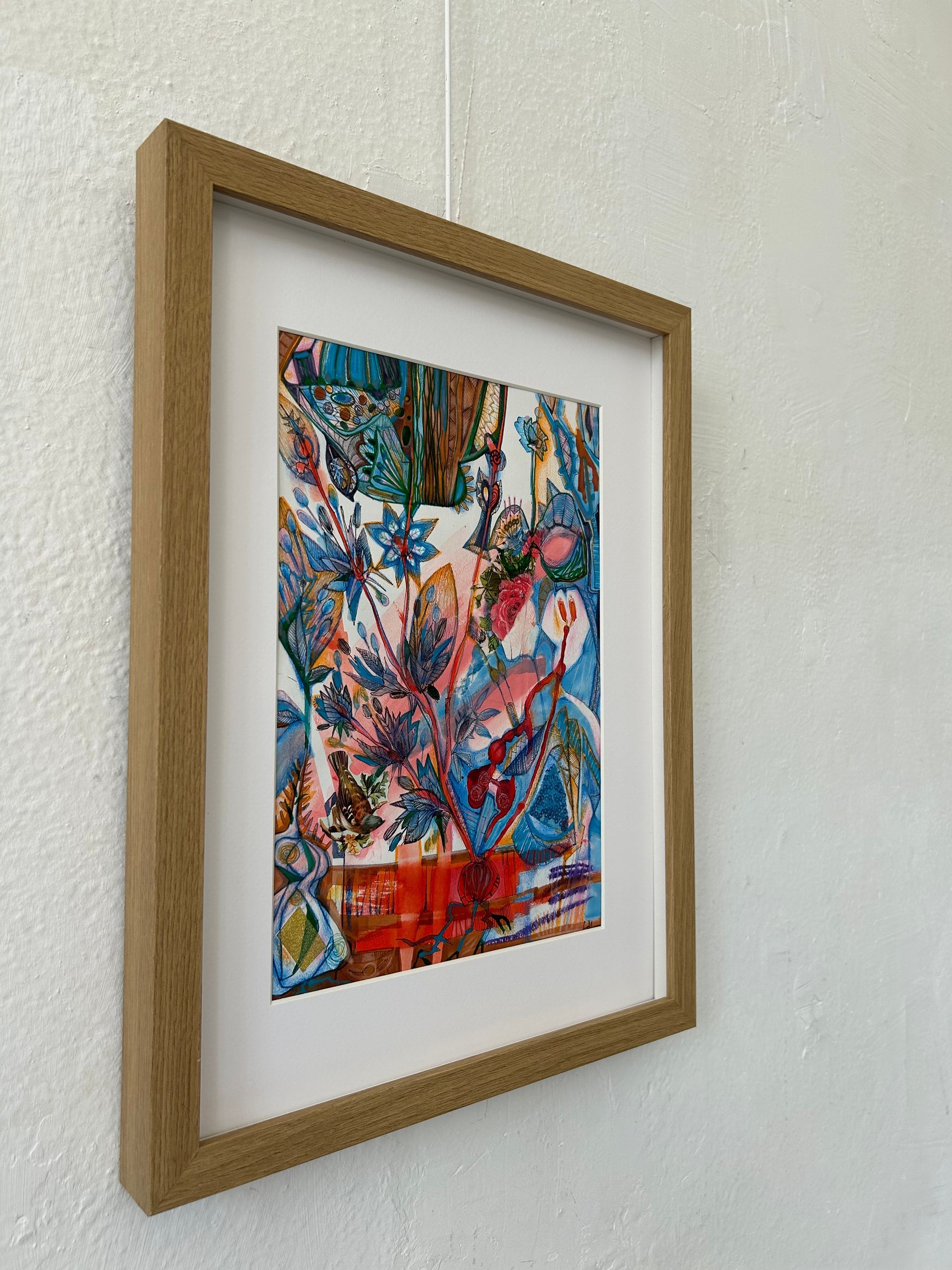Ingelijste, kleurrijke abstracte kunstwerken hangen aan een witte muur.