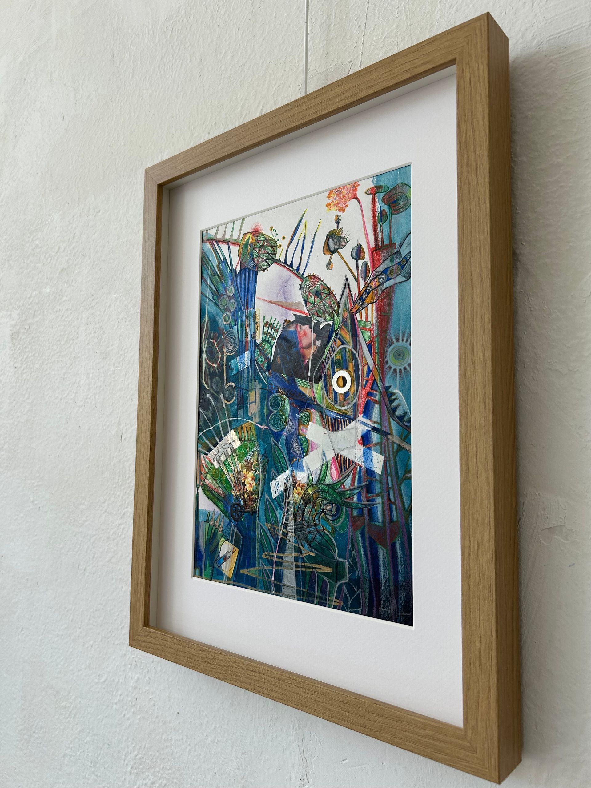 Ingelijst, kleurrijk abstract kunstwerk met planten op een witte muur.