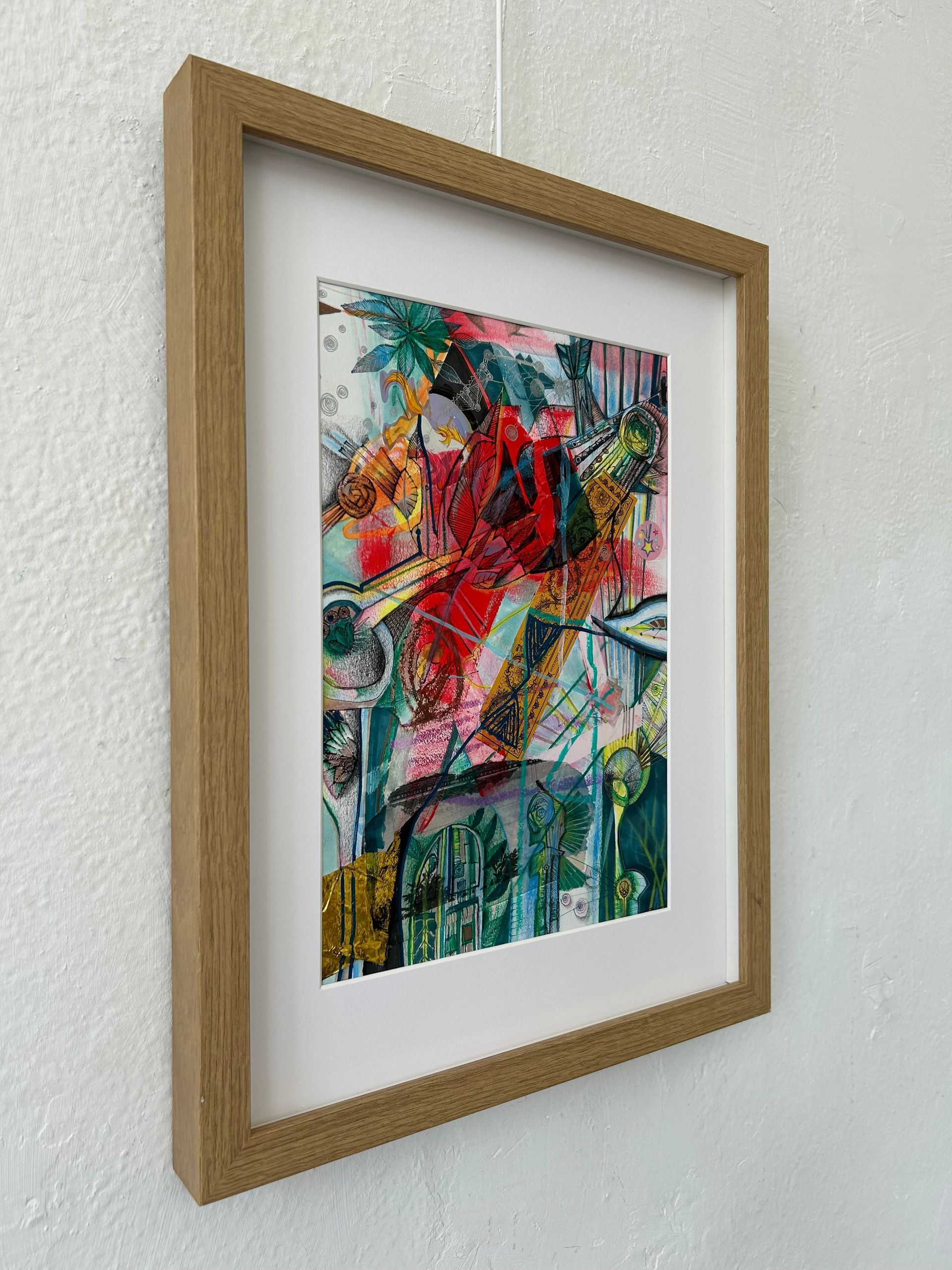 Ingelijst abstract, kleurrijk kunstwerk aan een witte muur, vanuit een bepaalde hoek bekeken.