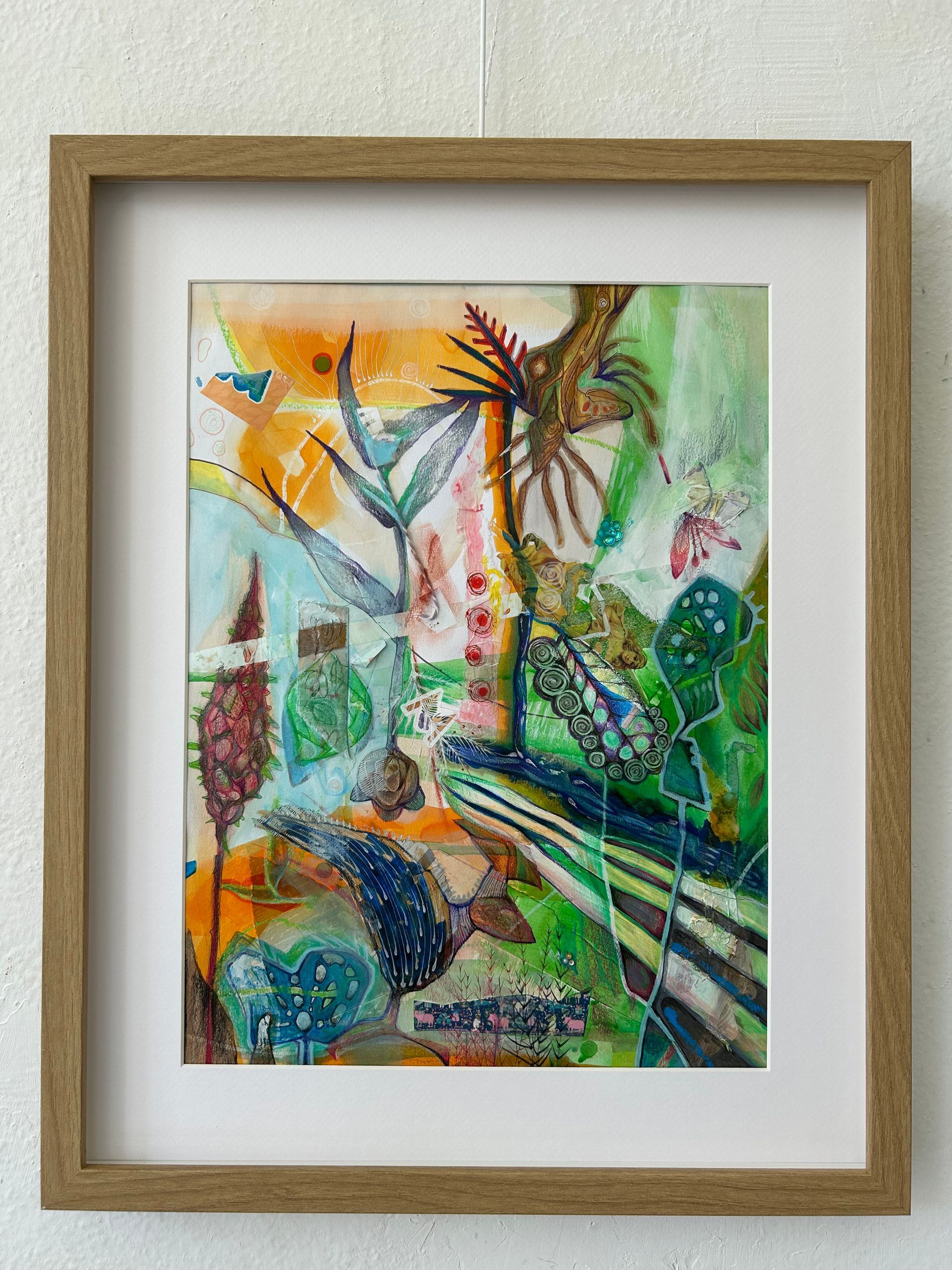 Abstract, kleurrijk schilderij in een houten lijst met groene, oranje en blauwe penseelstreken.